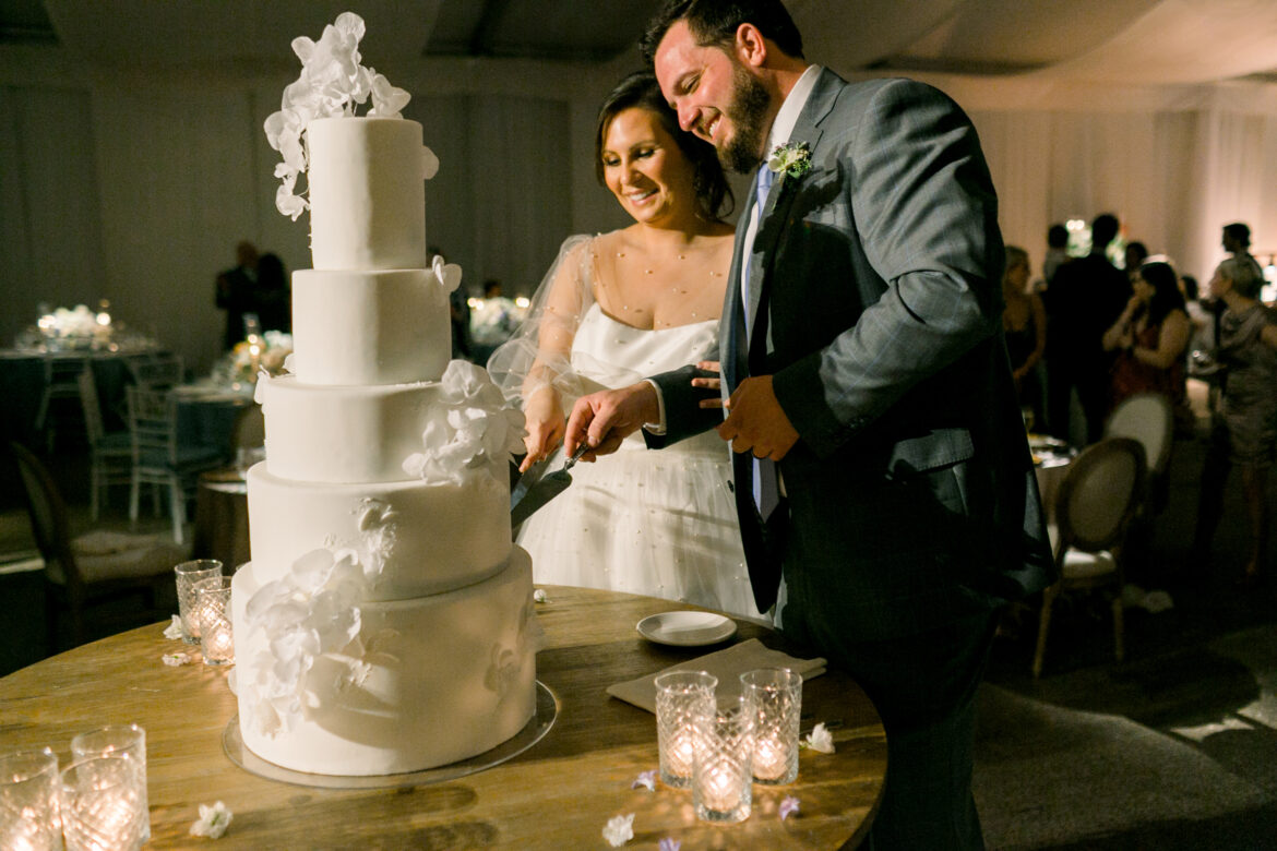 The bride and groom cut the cake designed by Sugar & Stems in this Southern wedding at Pursell Farms.