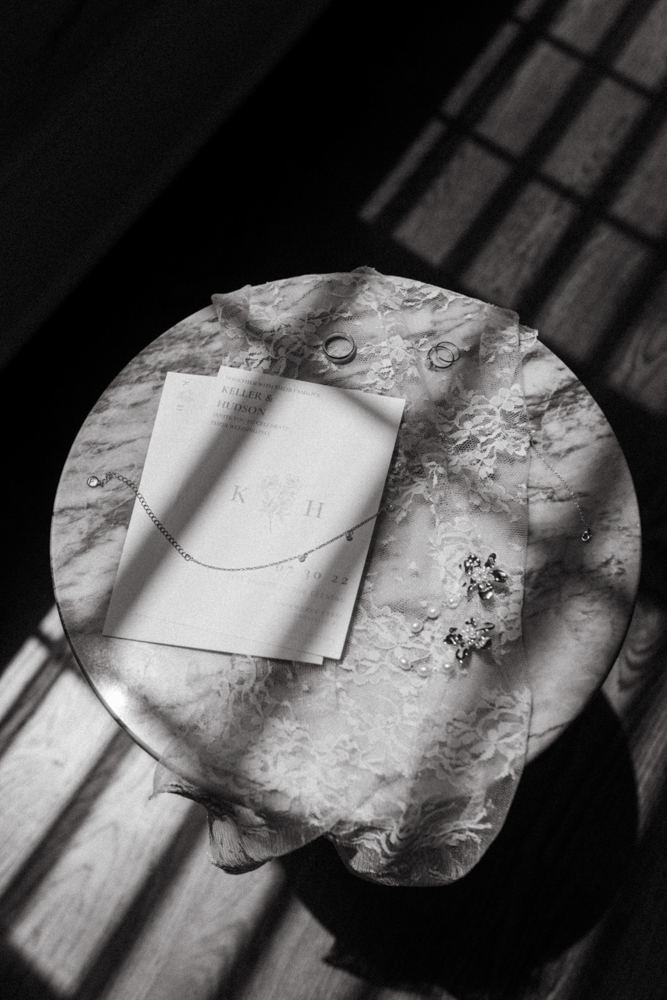 The wedding invitations are photographed with the bride's accessories.