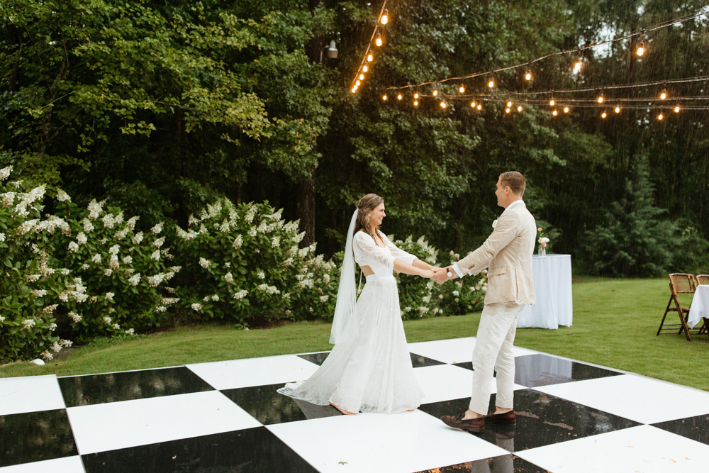 The bride and groom dance in the rain on their Alabama wedding day.