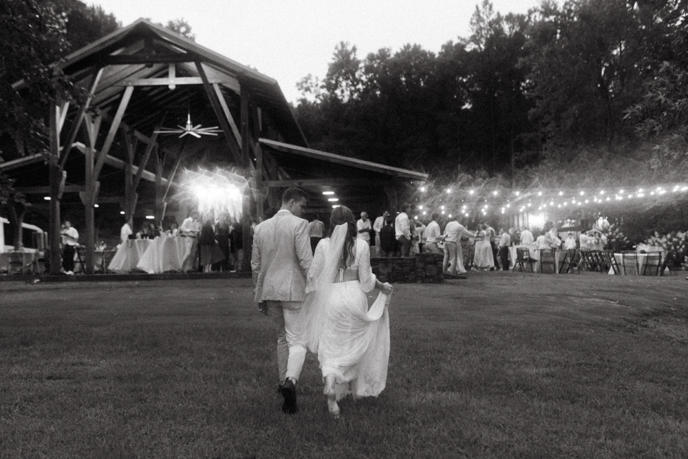 The bride and groom walk to their wedding reception in the rain.