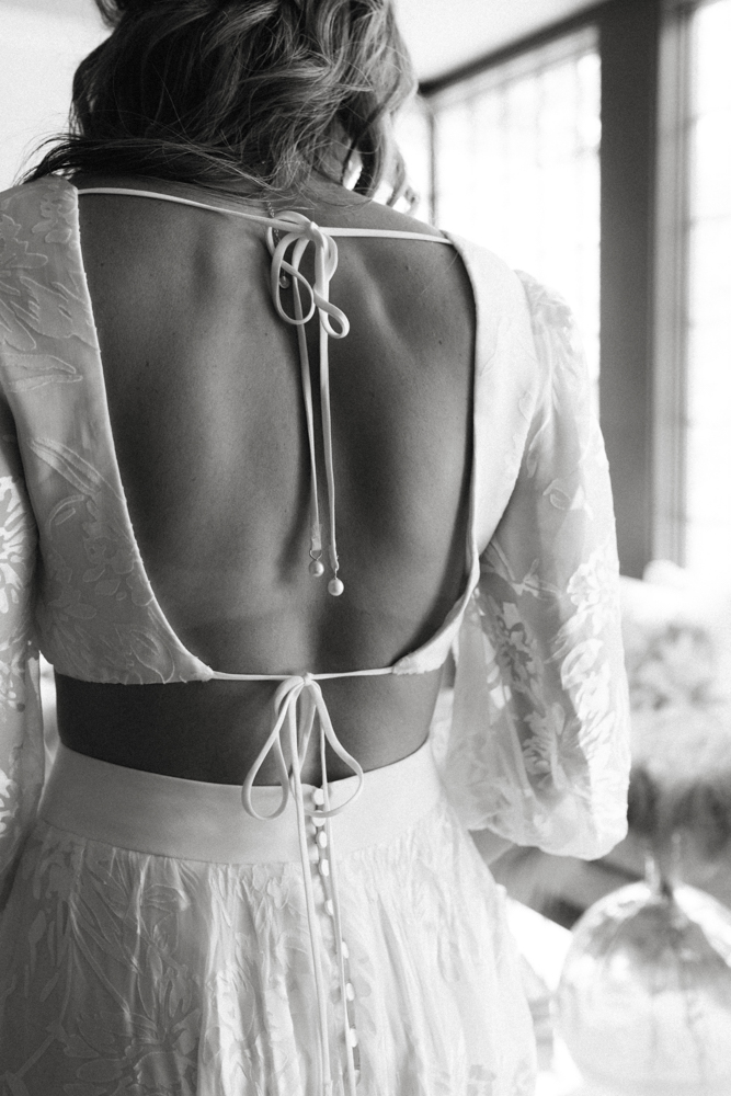 The bride shows the back detail of her Alabama wedding dress with buttons.