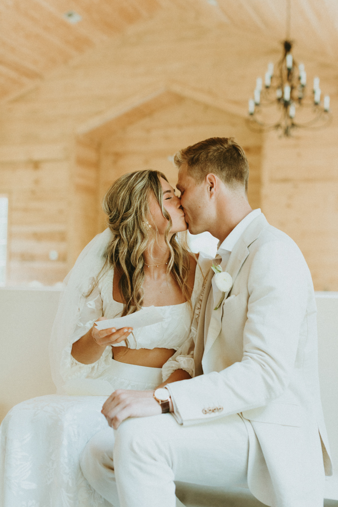 The bride and groom kiss as they read letters to each other.