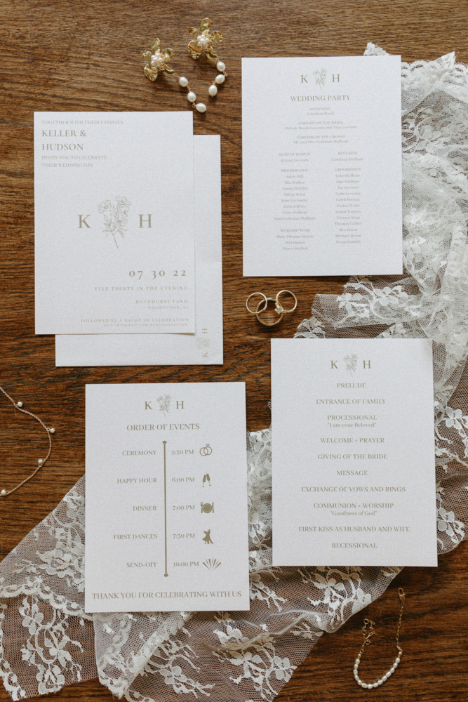 The wedding invitations are photographed with lace and jewelry.