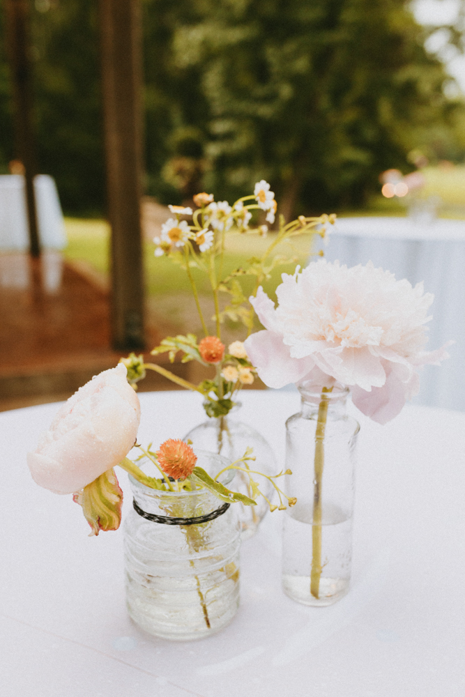 Bud vases hold flowers on a cocktail table.