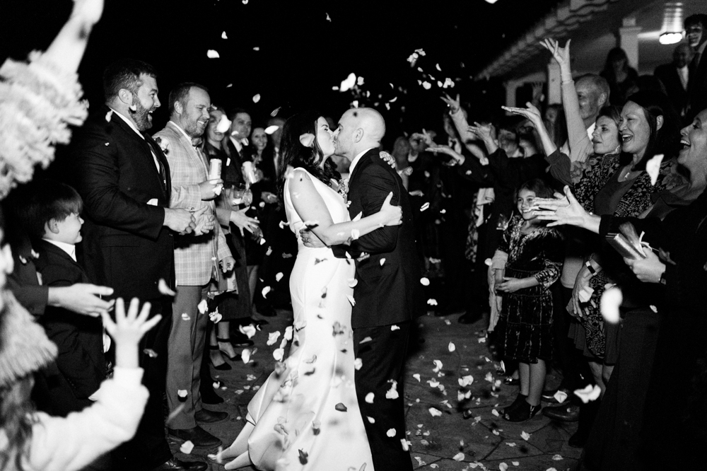 The bride and groom share a kiss as they exit their Southern wedding.