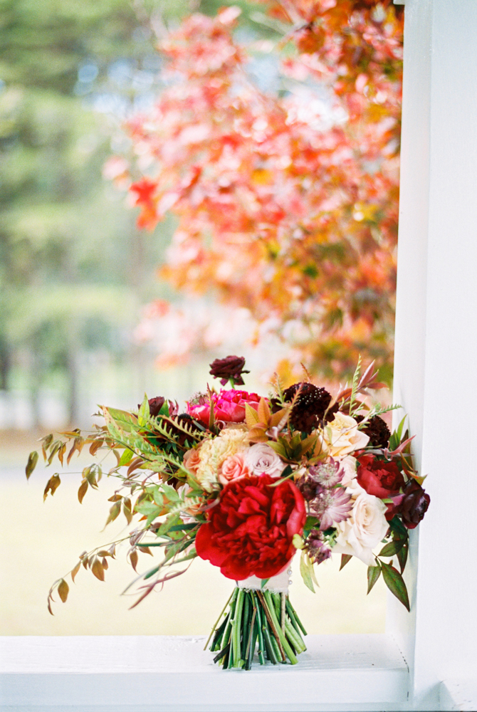 The fall bouquet of flowers is photographed on the porch for this Birmingham autumn wedding.