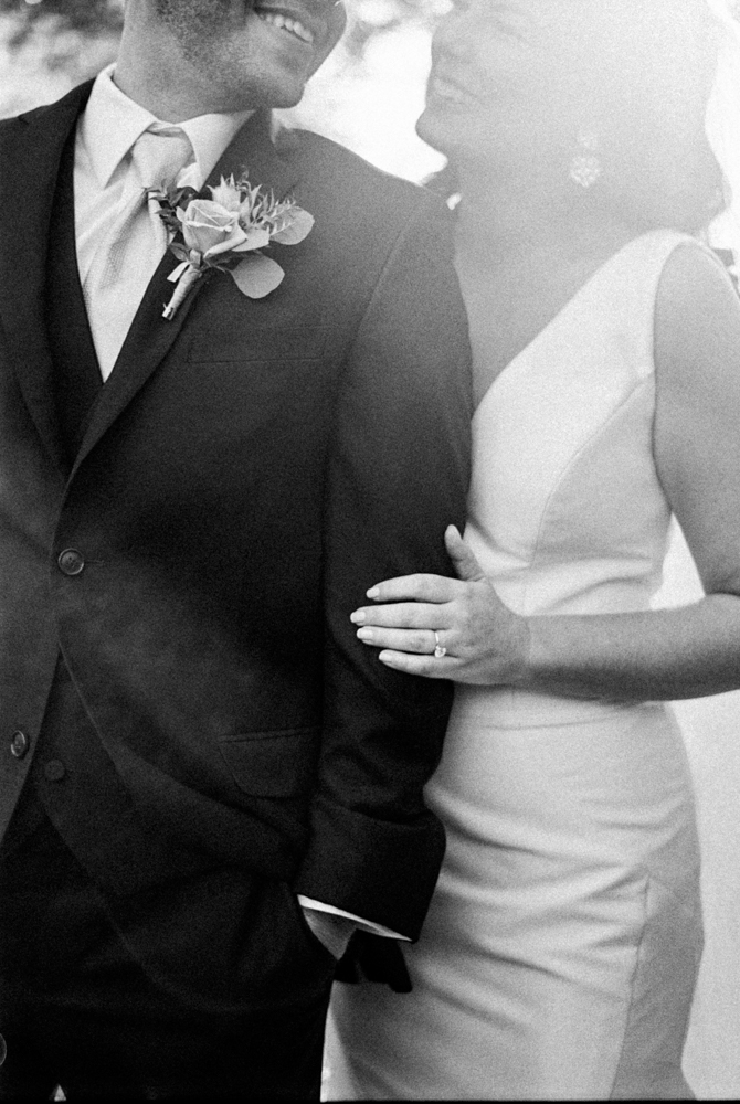 The bride holds the groom's arm in this portrait by Piper Vine.