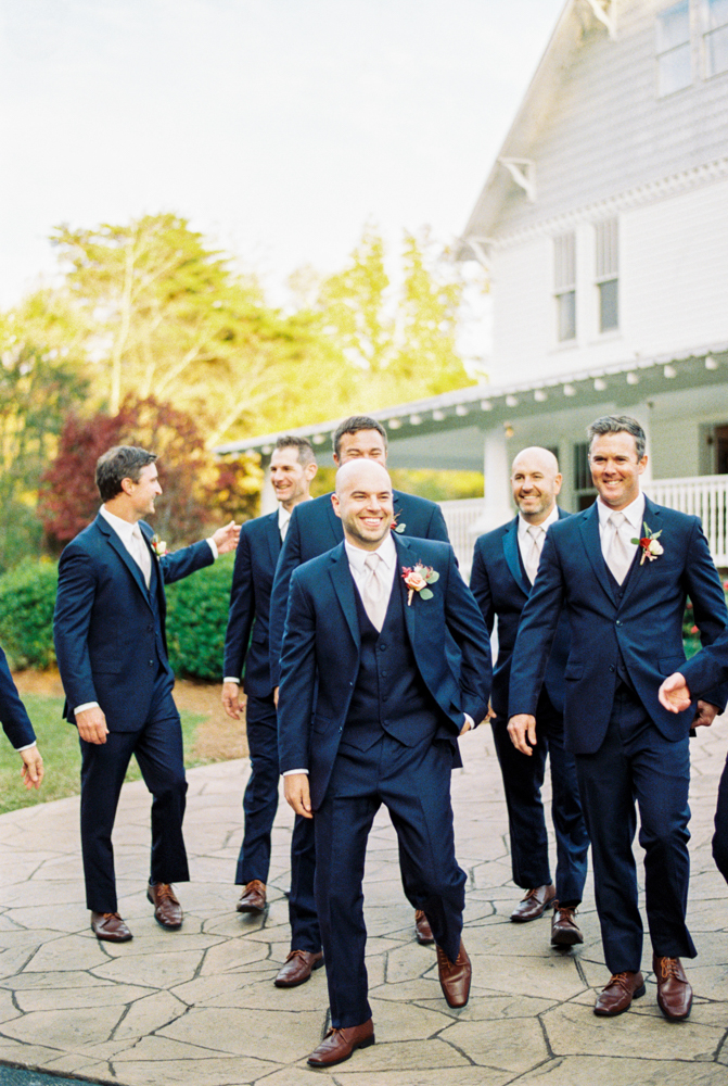 The groom walks with his groomsmen before this fall wedding ceremony in Birmingham.