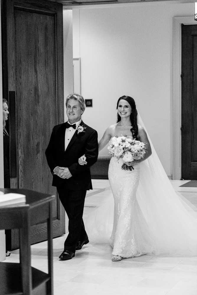 The father of the bride enters the church with his daughter for this Birmingham wedding ceremony.