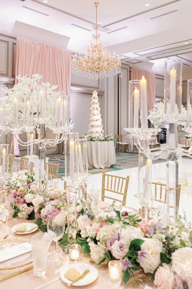 The wedding reception at Grand Bohemian Hotel Mountain Brook is set with tablescapes and a wedding cake.