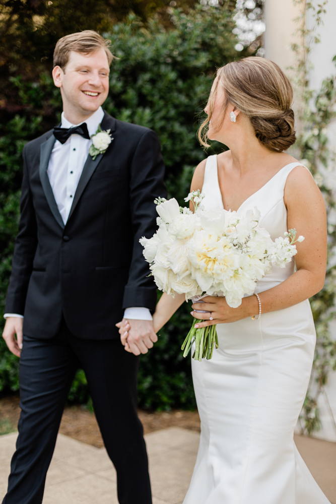 The bride and groom hold hands before the wedding ceremony at Huntsville Botanical Garden.