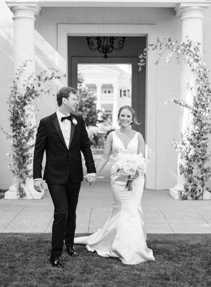 The bride and groom hold hands at Huntsville Botanical Garden.