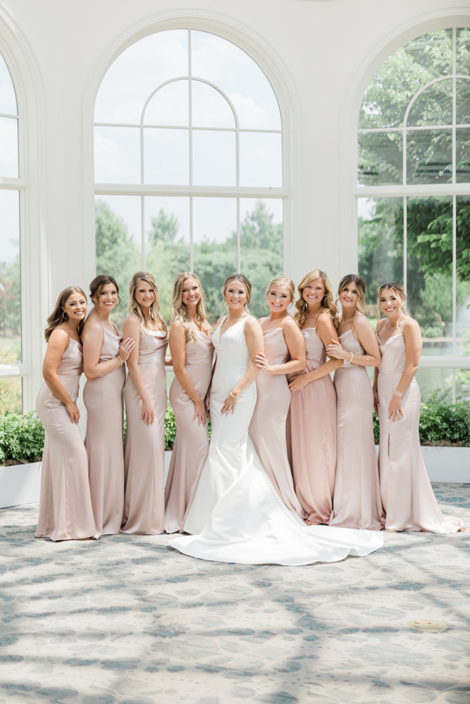 The bride joins her bridesmaids in the atrium of Huntsville Botanical Garden.