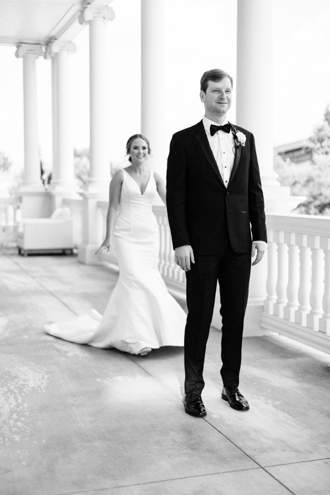 The bride approaches the groom for the first look on the veranda at Huntsville Botanical Garden.