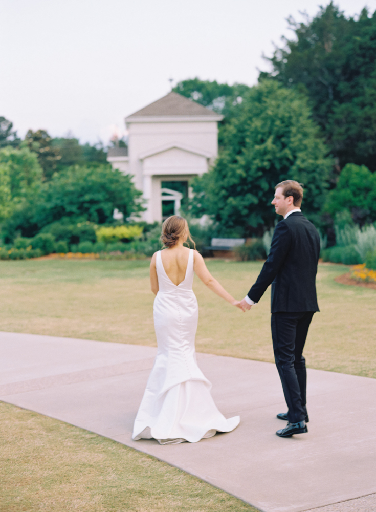 The bride and groom walk through the gardens at Huntsville Botanical Garden.