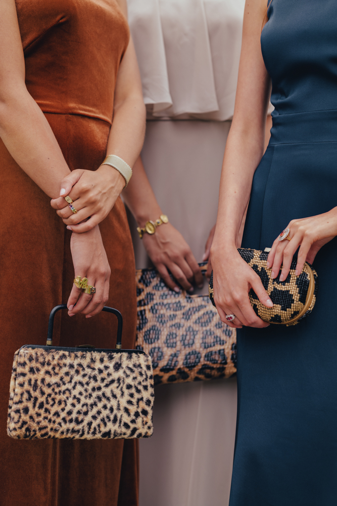 Bridesmaids wear dresses from Imperial Formal Wear while holding leopard print clutches.