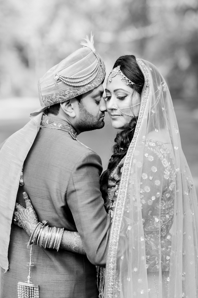 The bride and groom embrace in traditional Indian attire for their Alabama wedding ceremony.