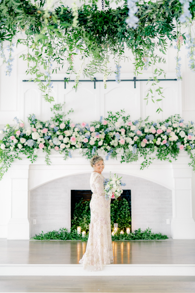 The bride poses with her bridal bouquet of flowers at Oak Meadow Event Center.