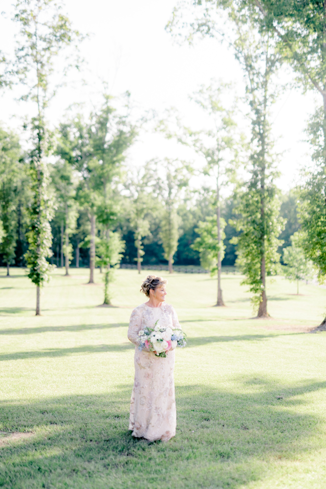 The bride poses for a bridal portrait her bouquet of flowers at Oak Meadow Event Center.