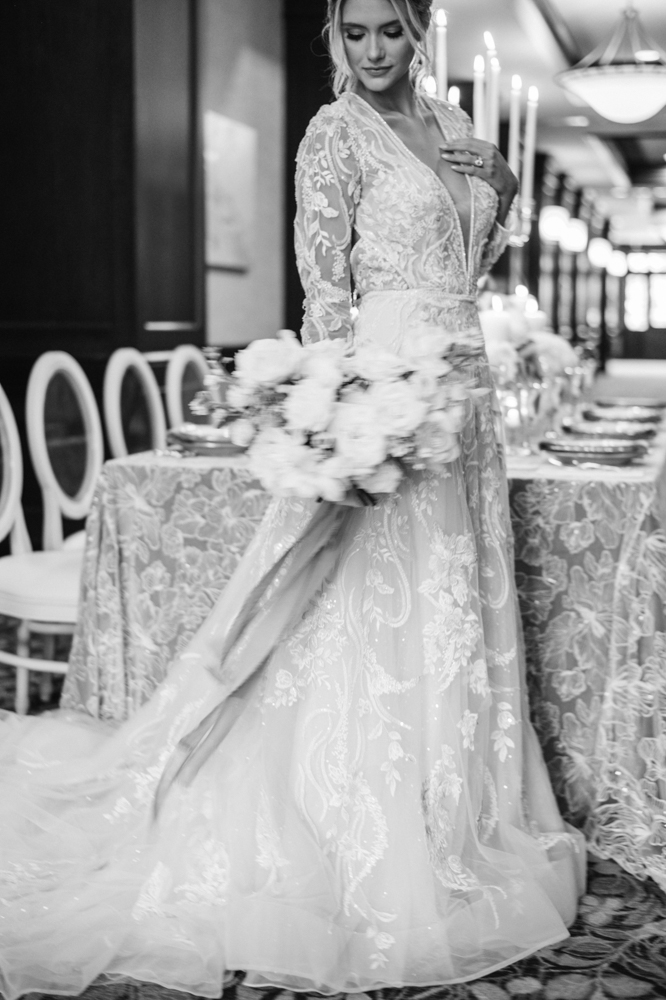 The bride poses with her bouquet in front of the winter tablescape designed by Anna Wynn Event Designs.