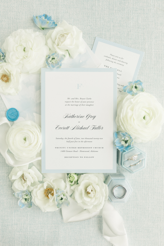 The wedding invitations are styled in a lay flat for this blue and white wedding.