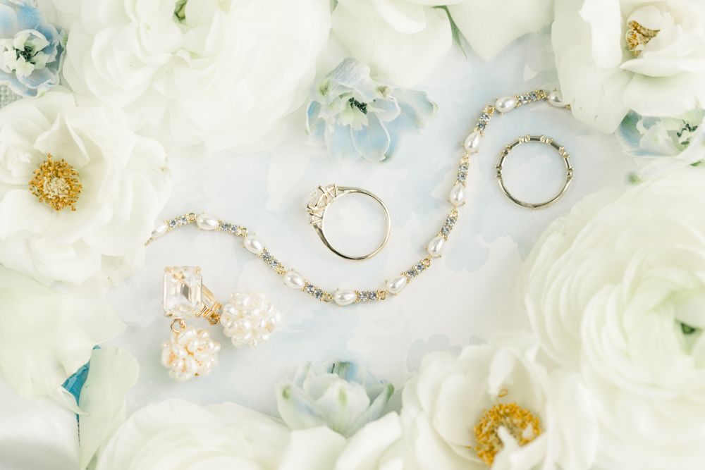 The bride's jewelry is styled with flowers for the Southern wedding.