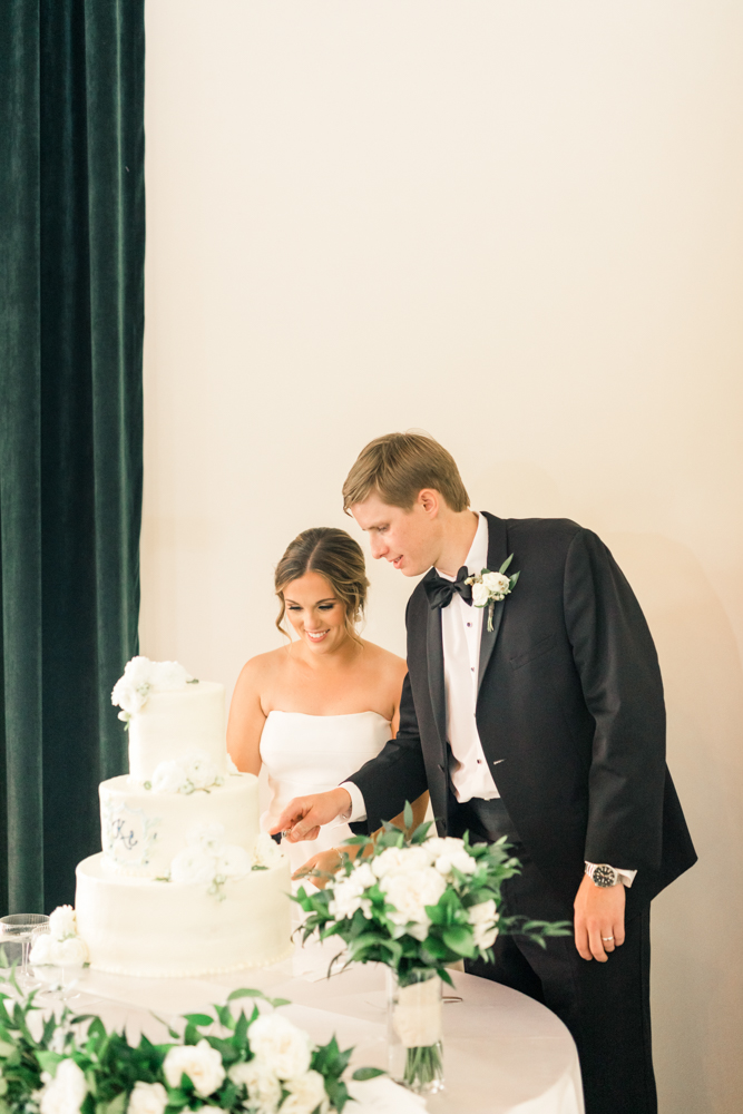 The bride and groom cut the cake during their Alabama wedding reception.