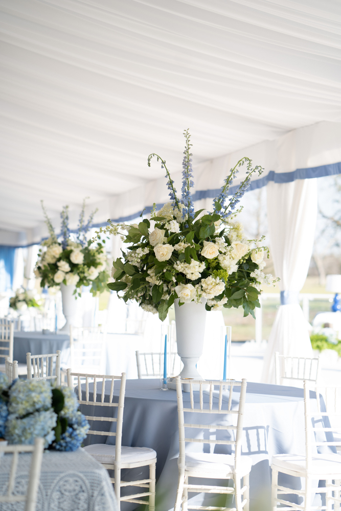 Floral centerpieces by Wildflowers Fairhope grace the tables of this Southern blue wedding.