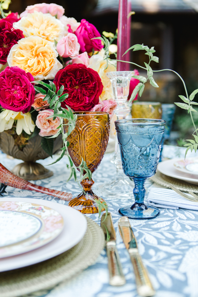 This Southern autumn tablescape features colored glass goblets and a centerpiece by Jubilee Flowers in Fairhope, Alabama.