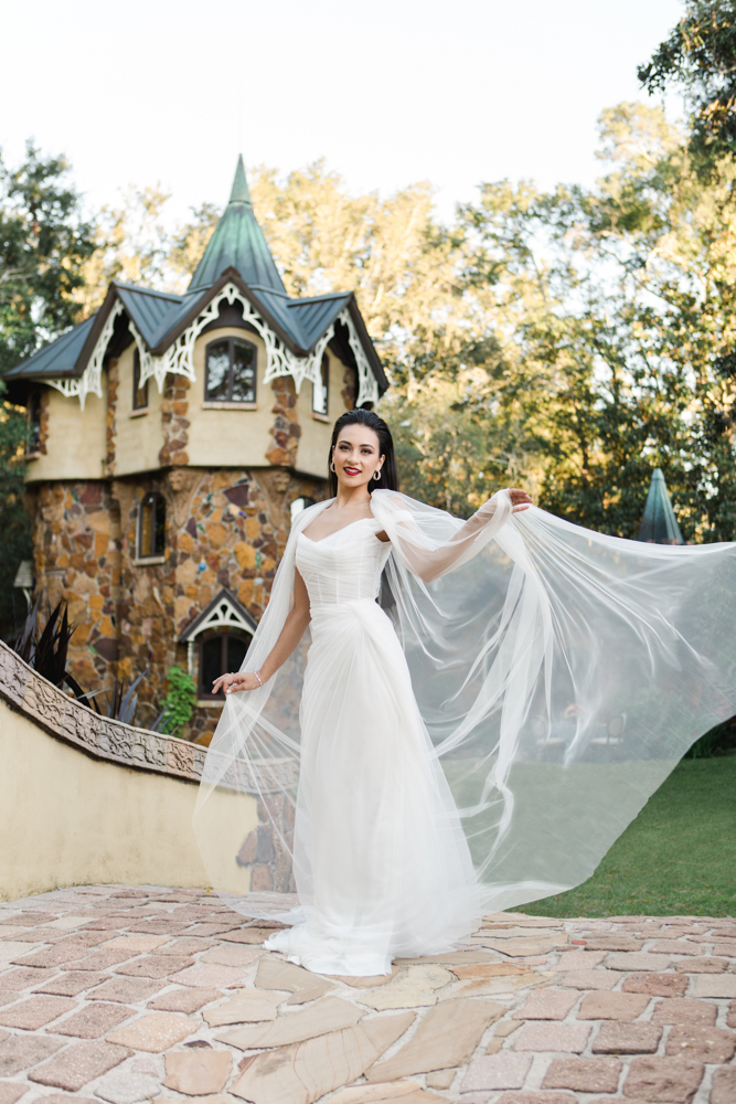 The bride celebrates her Southern wedding in front of Fairhope's Storybook Castles.