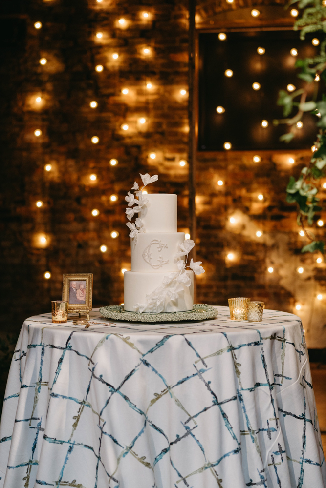 A wedding cake by Cakes by Kim is set on the stage of B&A Warehouse for this Southern styled feature by CONFERO.