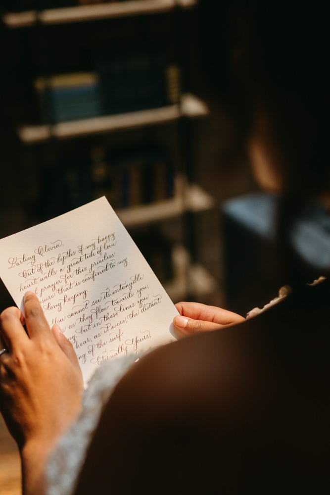 The bride reads a hand-lettered note from Penned by Chrissy in Birmingham, Alabama.