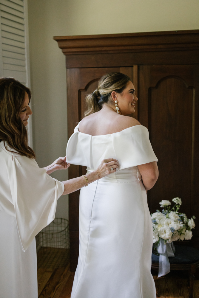 The Huntsville bride puts on her wedding dress in Alabama.