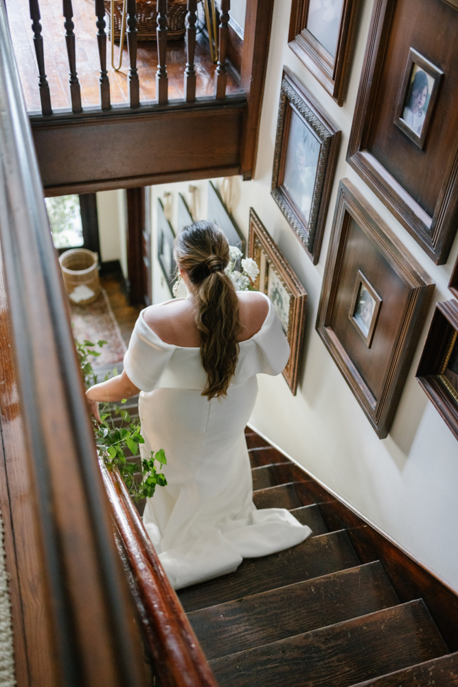 The bride walks down the stairs of her family home in Huntsville, Alabama.