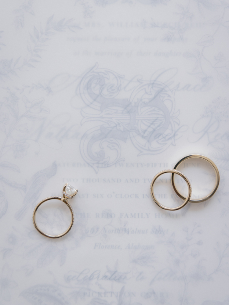 The wedding rings are photographed on the Southern wedding invitations.