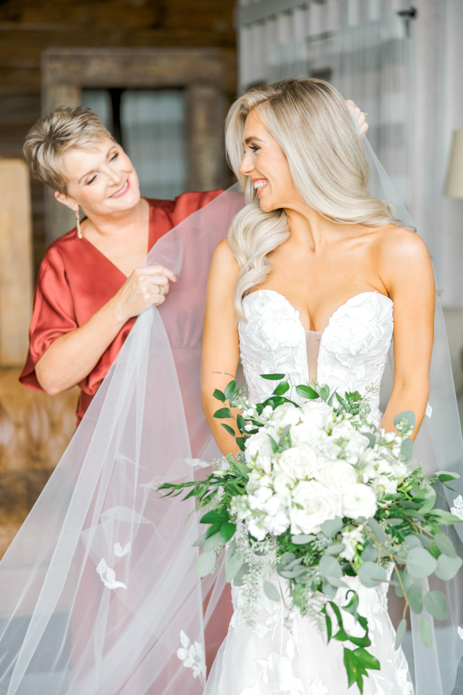 The mother of the bride adjusts her daughter's veil before her Southern wedding at Burns Bluff at High Falls.