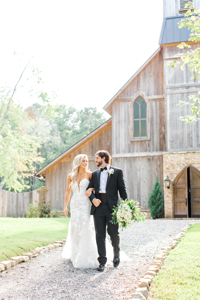 The bride and groom walk together on the grounds of Burns Bluff at High Falls.