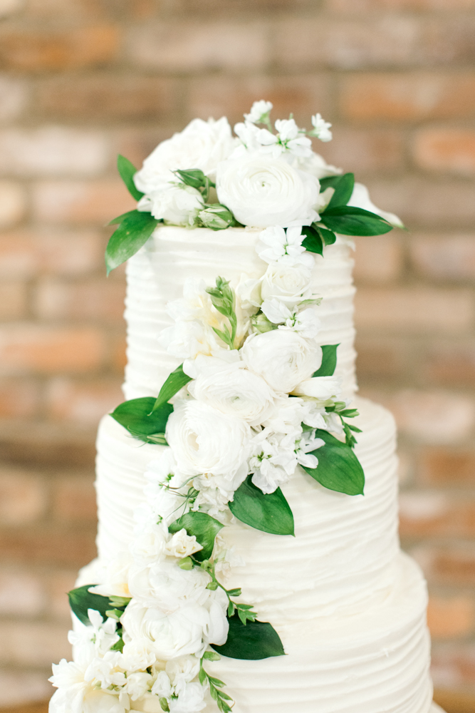 The classic Southern wedding cake features white flowers at Burns Bluff at High Falls.