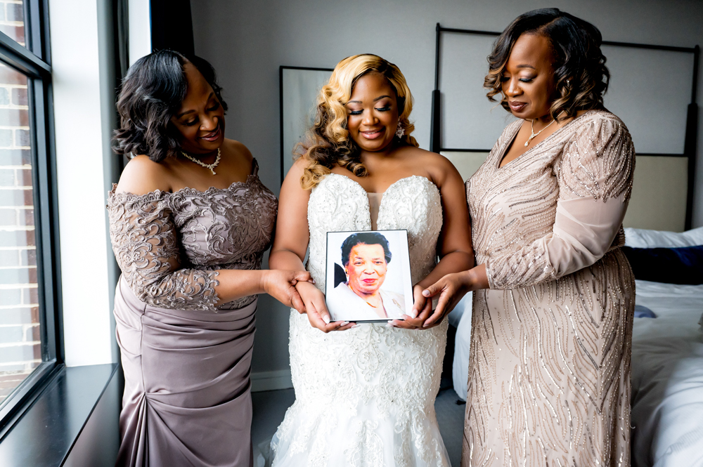 The family holds a photograph together before a Birmingham wedding.