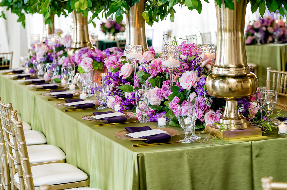 The tablescape of this Birmingham wedding reception has purple flowers with green linen.