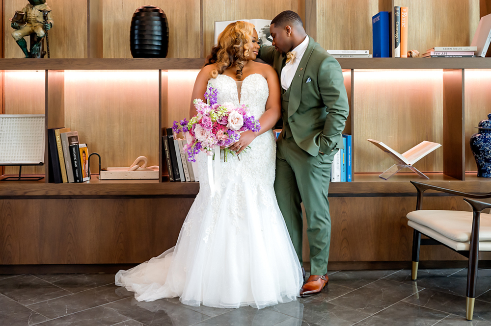 The bride holds her bouquet as her groom looks at her before their Birmingham wedding.