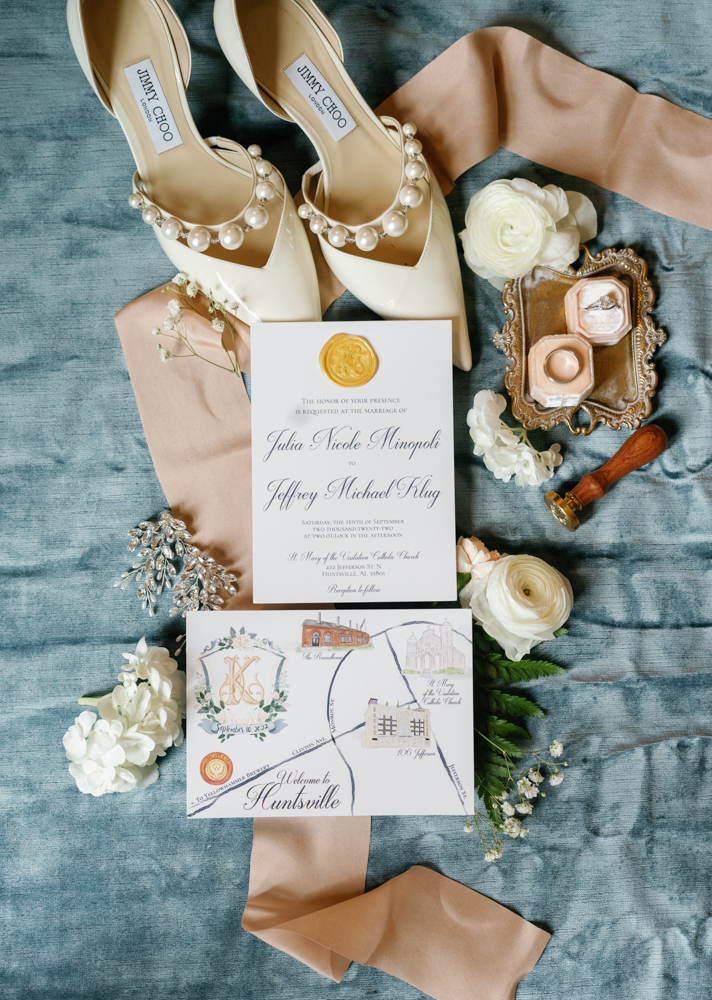 The Huntsville wedding invitations are photographed in a lay flat style with the bride's accessories.