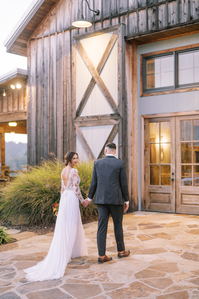 The bride and groom walk together on their fall wedding day in Alabama.