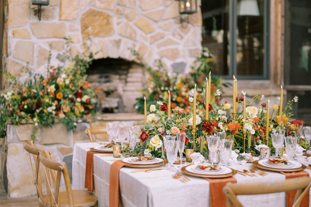 The fall wedding tablescape is set with flowers by Sugar & Stems at Otter Creek Farmstead in Alabama.