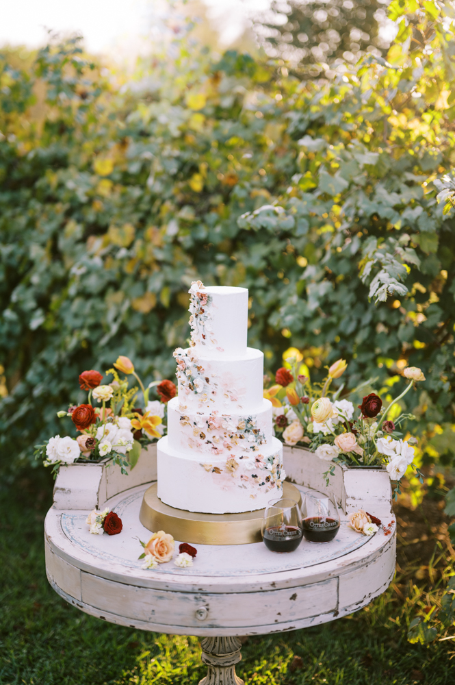 Twenty Oaks Photography captures a beautiful cake and flowers by Sugar & Stems in the grapevines at Otter Creek Farmstead.