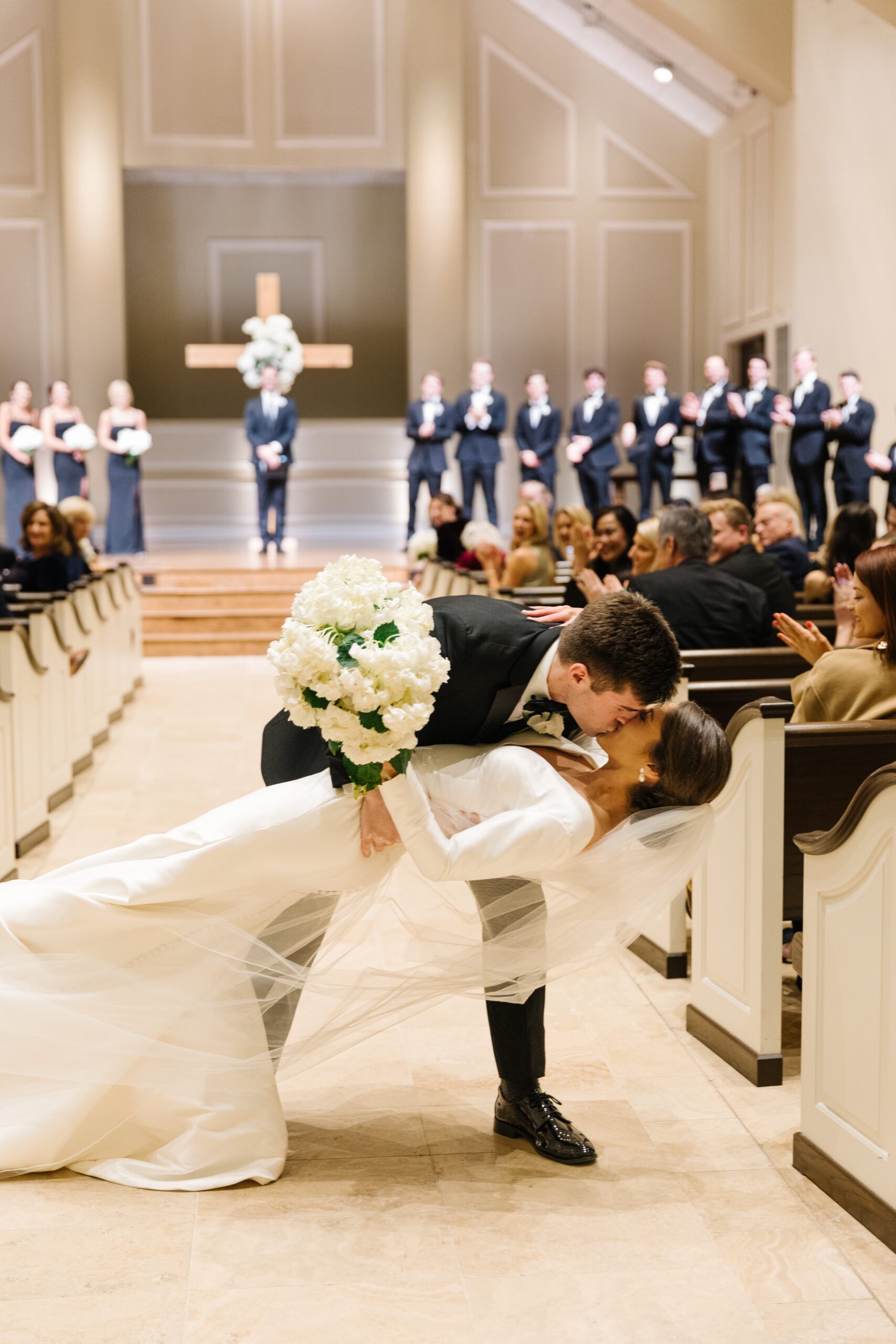 The bride and groom kiss during their wedding ceremony in Alabama.