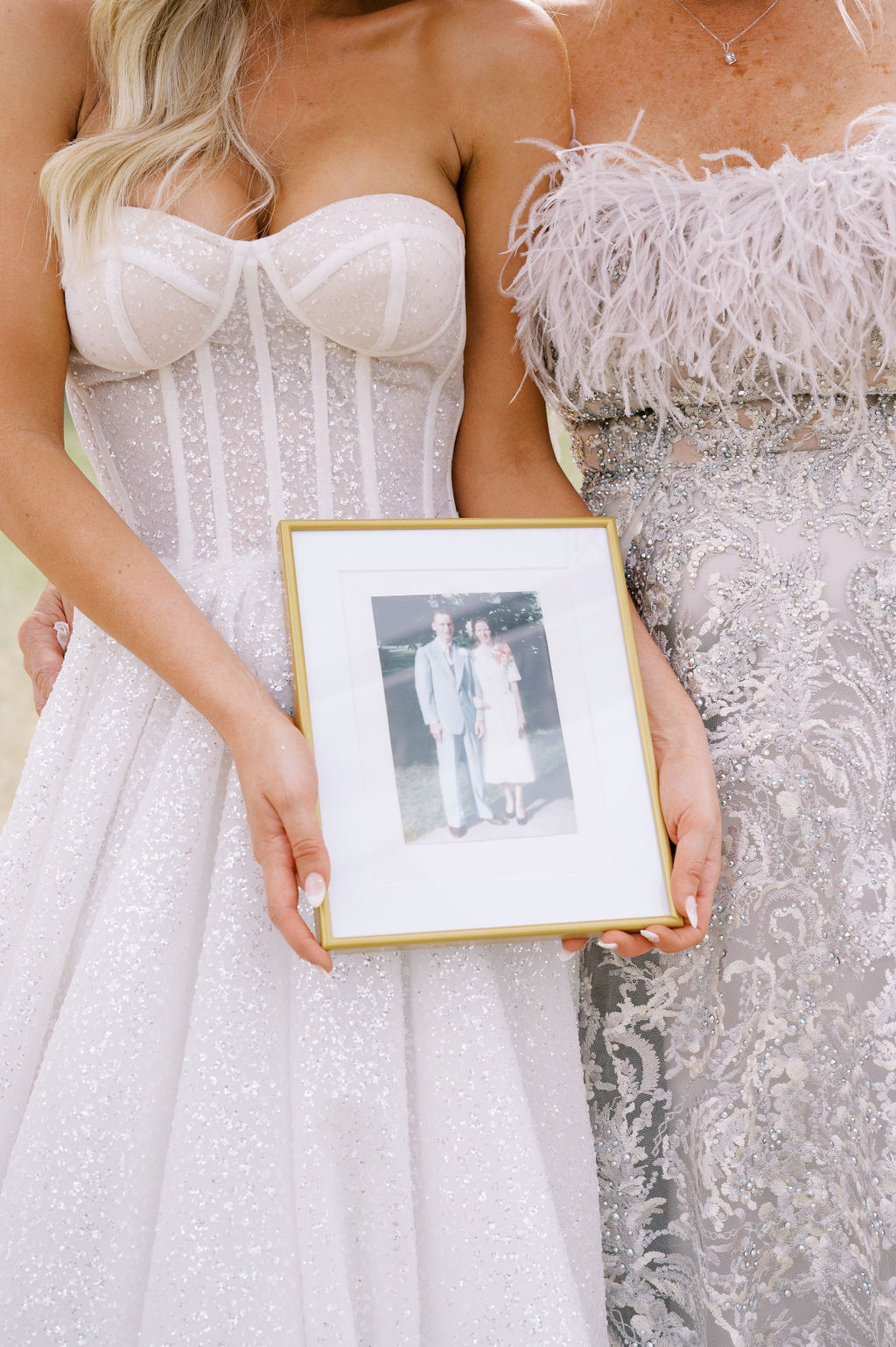 The mother and daughter hold a family photograph at this Southern wedding.