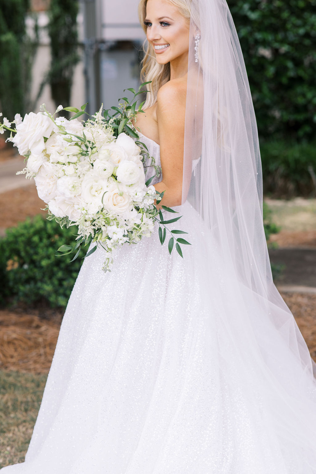 An Alabama bride holds a white bouquet of flowers for her Auburn wedding ceremony.