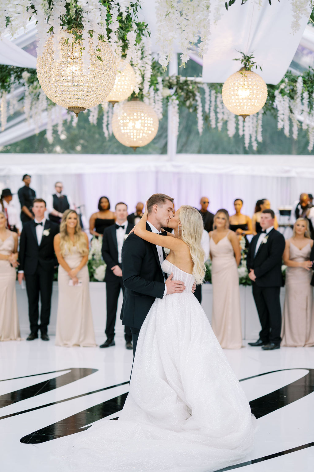 The bride and groom kiss during the first dance in this tented wedding reception in Auburn, Alabama.