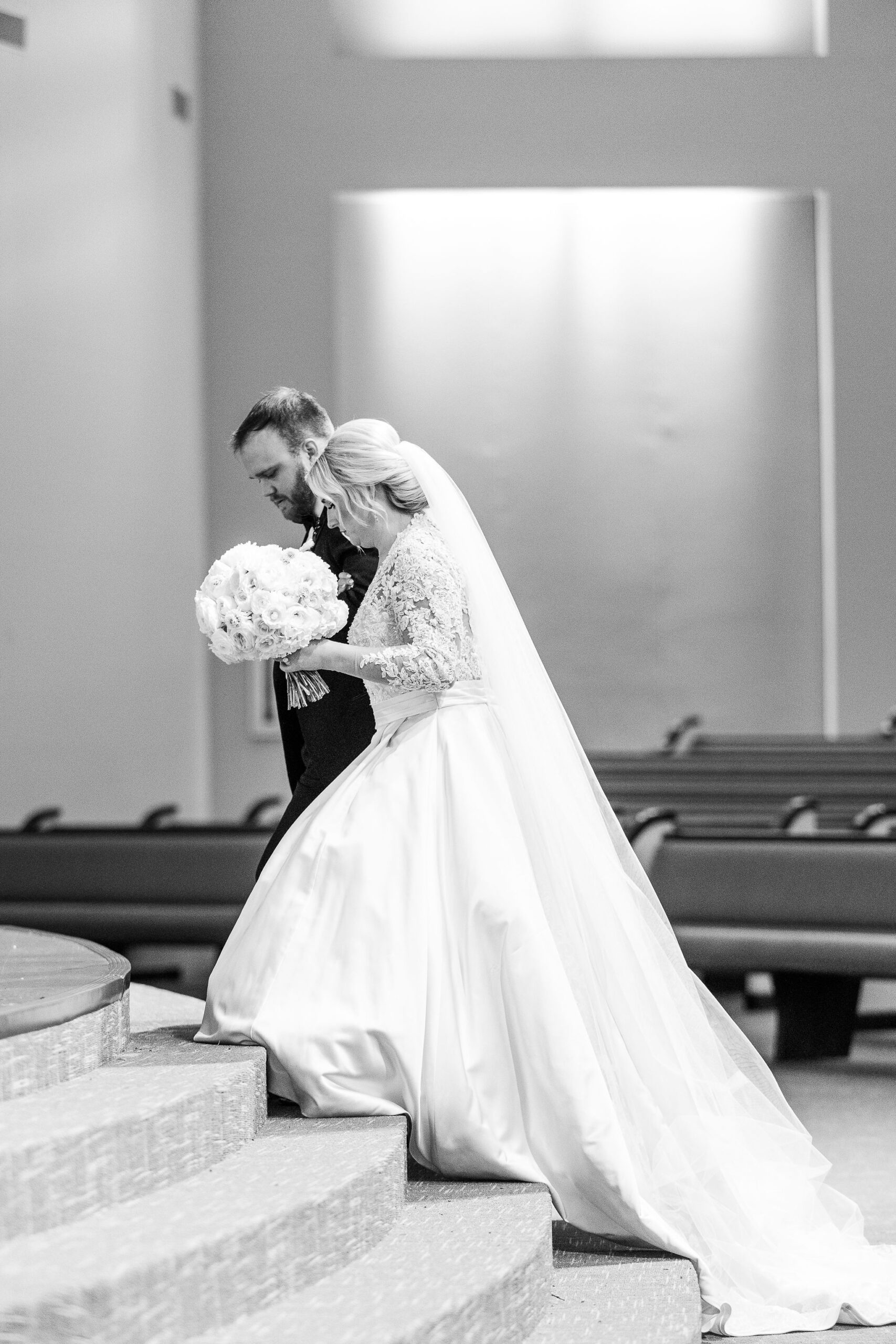 The bride and groom walk up steps during their Alabama wedding ceremony.